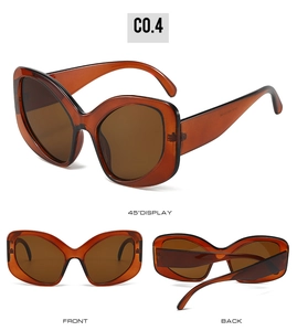 Detail view of oversized cat-eye sunglasses with transparent amber frames and brown lenses
