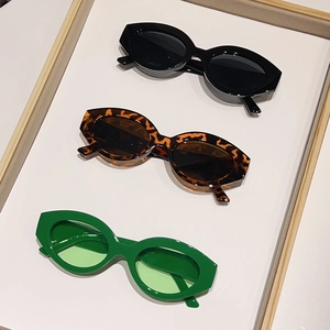 Three pairs of trendy cat-eye sunglasses in black, tortoiseshell and green colors