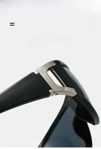 Detail of silver D-shaped metal hinge on stylish black sunglasses with durable PC frame