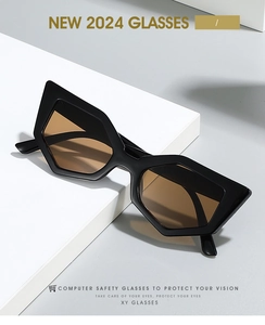 Détail de lunettes de soleil œil-de-chat noires avec verres ambrés sur escalier blanc