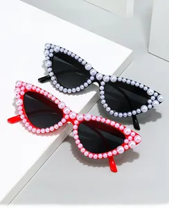 Vue détaillée des lunettes de soleil œil de chat ornées de perles sur montures rouges et noires