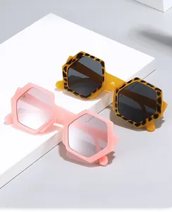 Detail of hexagonal sunglasses in pink transparent and tortoiseshell frames on props