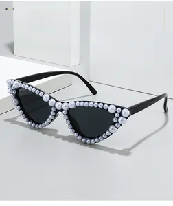 Gros plan sur des lunettes de soleil œil-de-chat ornées de perles blanches sur monture noire