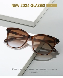 Detail of oversized tortoiseshell cat-eye sunglasses with brown gradient lenses and glossy finish