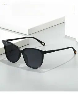 Detailed close-up of thick black lenses and gold teardrop detail on cat-eye sunglasses