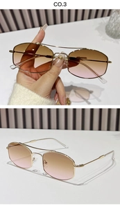 Detail of gold metal double bridge frame and brown to pink gradient lenses on sunglasses