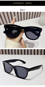Detail view of black square sunglasses with silver accents and gray lenses