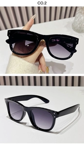 Detail of black square sunglasses with silver rivets and gradient purple lenses