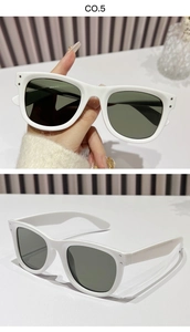 Detail view of white thick-frame sunglasses with dark grey lenses in a modern chic style