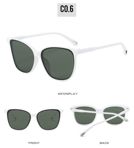 Detail view of white cat-eye sunglasses with green lenses and gold drop metal accents