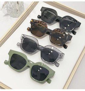 Detailed display of chunky geometric sunglasses in black, tortoiseshell, grey, and green