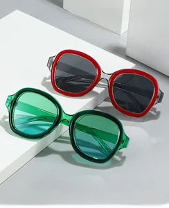 Détail de lunettes de soleil Y2K rouges et vertes sur des supports géométriques