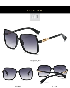 Detail of oversized square sunglasses featuring golden geometric hollow metal temples