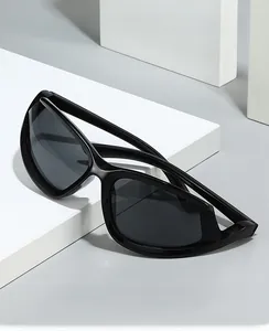 Detail of black wraparound Y2K sunglasses with sleek streamlined frames and dark lenses