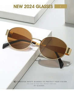Detailed close-up of oval gold metal frame sunglasses with brown lenses on white display