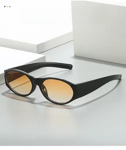 Detail of retro oval sunglasses with orange gradient lenses on a minimalist background