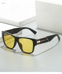 Détail de lunettes de soleil carrées avec verres jaunes et branches métalliques chics