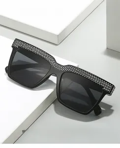 Macro detail of black square sunglasses featuring luxury silver rhinestones on the frame top