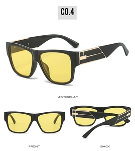 Détail de lunettes de soleil noires carrées avec verres jaunes et décorations dorées sur les branches