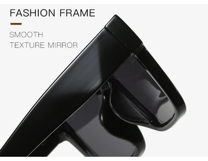 Detail of square black sunglasses showing smooth texture and reinforced metal hinges
