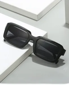 Detail of 2024 rectangular black thick frame sunglasses on a white geometric platform