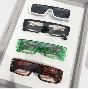 Detail of four rectangular sunglasses featuring golden panther motifs on the side frames
