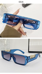 Detail of blue rectangular sunglasses with golden leopard emblem on temples and gradient lenses