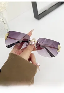 Detail of rimless sunglasses with purple gradient lenses and gold butterfly accents