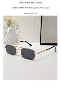 Detail view of gold metal double bridge square sunglasses with black lenses on a white desk