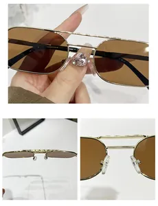 Detail of gold double-bridge sunglasses with textured top bar and brown lenses