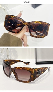 Détail de lunettes de soleil en écaille avec branches larges et anneau en métal doré