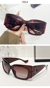 Détail de lunettes de soleil ambre avec décoration anneau métallique sur la branche
