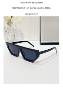 Detail of modern black geometric sunglasses with thick resin frames on a white table