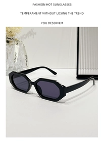 Détail de lunettes de soleil octogonales noires avec verres foncés sur table blanche