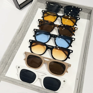Varietà di occhiali da sole quadrati alla moda in vari colori su un vassoio grigio premium