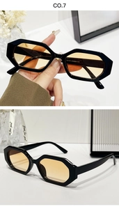 Détail de lunettes de soleil hexagonales avec verres orange et monture noire épaisse