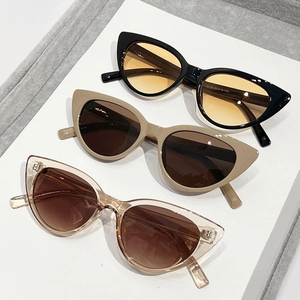 Three pairs of vintage cat-eye sunglasses with thick frames and colorful lenses in a row