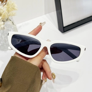 Handheld vintage white cat-eye sunglasses with dark grey lenses and wide frames