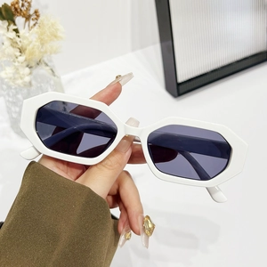 Lunettes de soleil géométriques blanches avec verres foncés dans un décor minimaliste
