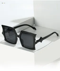 Close-up of black oversized geometric sunglasses with unique star-accented rectangle frames