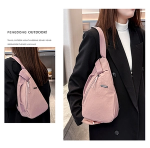 Pink nylon crossbody sling bag worn on front and back views against black suit jacket