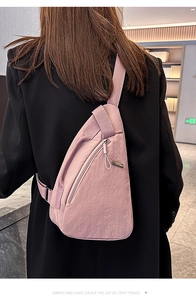 Detail of pink nylon crossbody chest bag with adjustable strap and waterproof texture