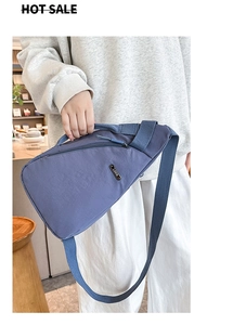 Detail of blue crossbody chest bag featuring a metallic LSNR logo and adjustable strap