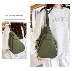 Detail view of military green nylon chest bag with adjustable strap and metal LSNR logo