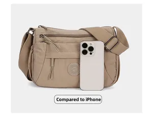 Detailed comparison of khaki multi-pocket crossbody bag with an iPhone for size reference