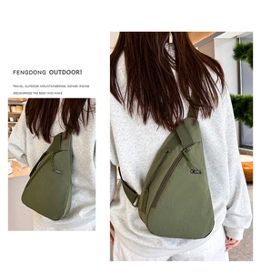 Detail of army green nylon chest bag showing water-resistant texture and zippered pockets