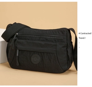Detail of waterproof black nylon crossbody bag featuring multi-pocket zipper layers