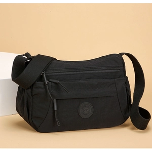 Close-up of waterproof black nylon crossbody bag featuring multi-layer zipper pockets