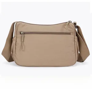 Rear view of khaki nylon crossbody bag featuring a horizontal zipper pocket and wide strap