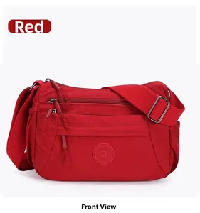 Detailed front view of red nylon crossbody bag featuring multiple zipper pockets